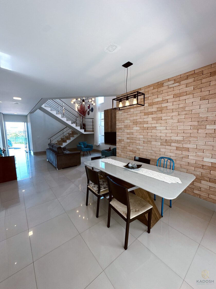Living integrado com jantar, parede de tijolinhos e escada